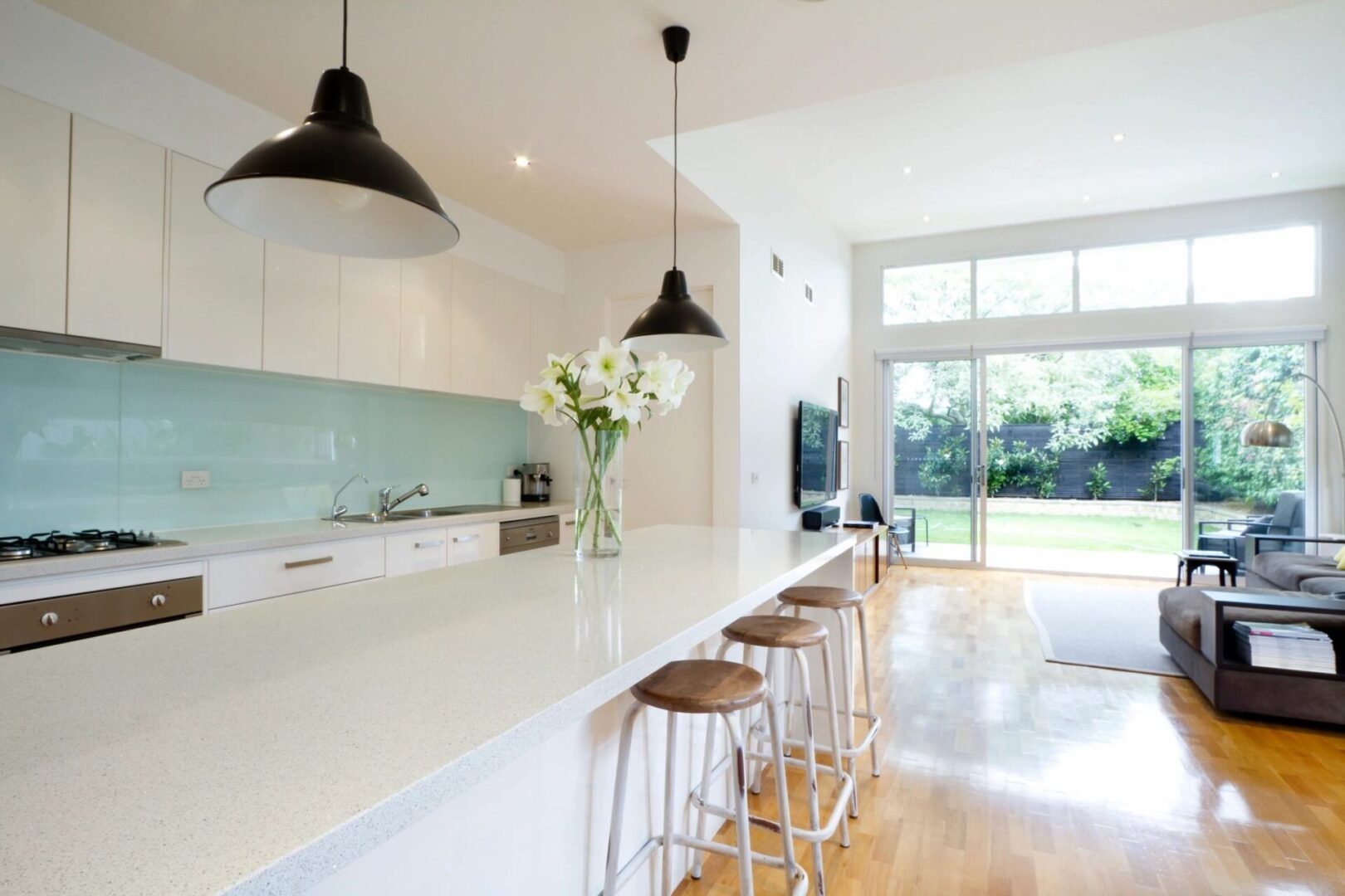 About London Kitchen and Bath - Modern kitchen with a large island and bar stools.